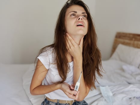 woman with a thermometer in her hands holds the neck upset fever photo
