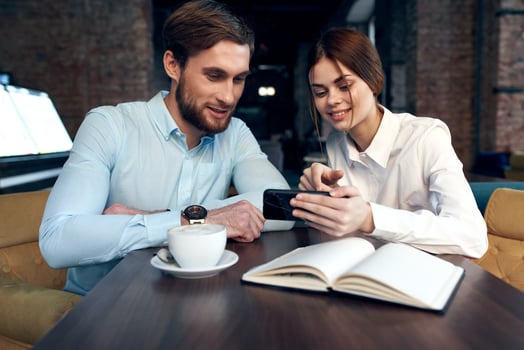business man and woman look at the phone communication work colleagues photo