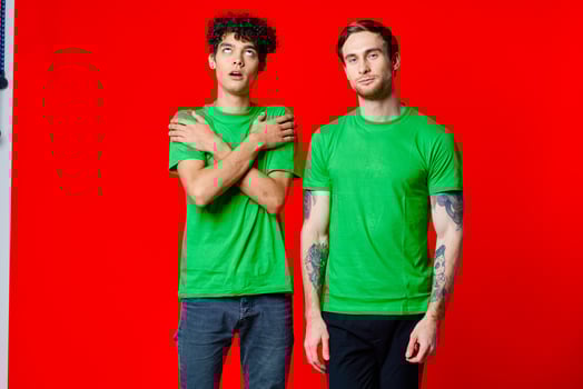 two friends in green t-shirts communication lifestyle red background photo