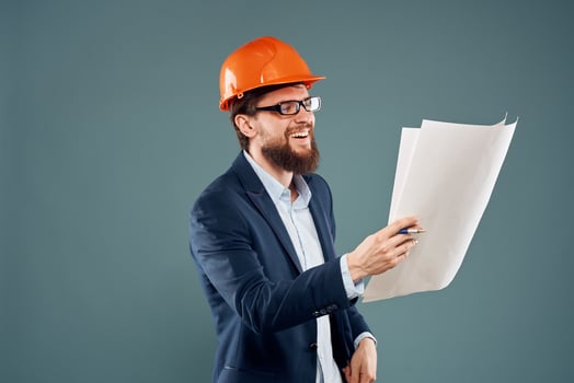 A man in orange paint blueprints in the hands of a construction industry official photo