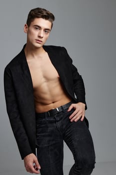 The man in the jacket holds his hand on his belt and leans to the side photo