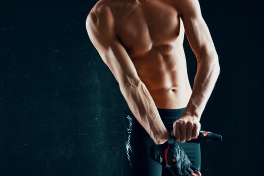 athletic men with a pumped-up body workout posing dark background photo