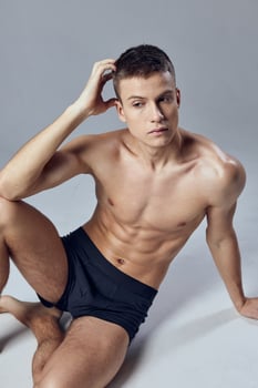 athletic men in white shorts sitting on the floor posing photo