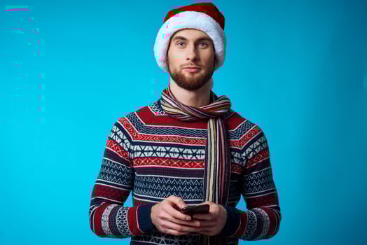 Cheerful man with a phone in hand holiday christmas technology blue background photo