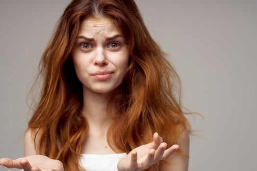 beautiful woman in a white t-shirt pimples on the face light background photo