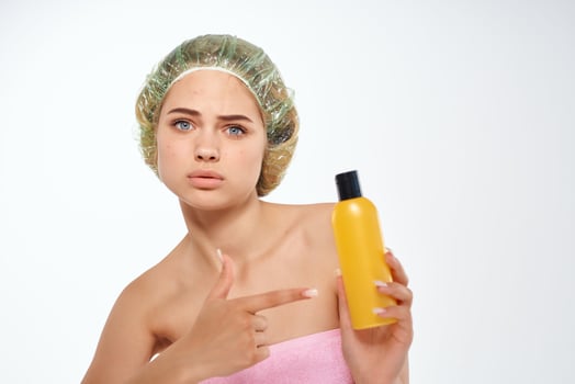 woman with pink towel nude ringlets cream skin care light background photo