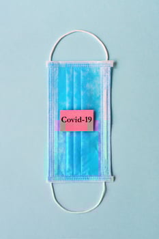 Coronavirus concept with medical mask and sign Covid-19 photo
