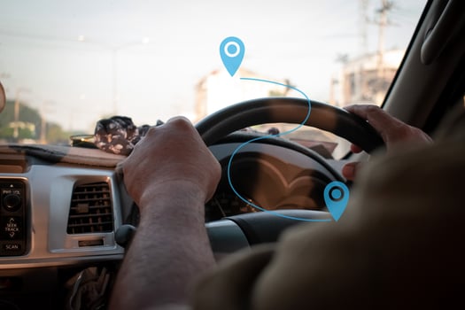 Man's hand holding steering wheel, driving on a country road photo