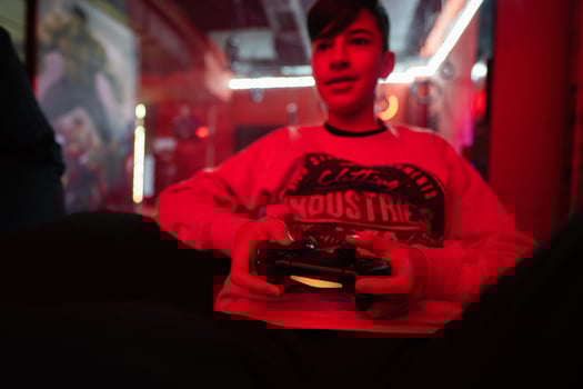 Teenager boy gamer play gamepad video game console in red gaming room. photo