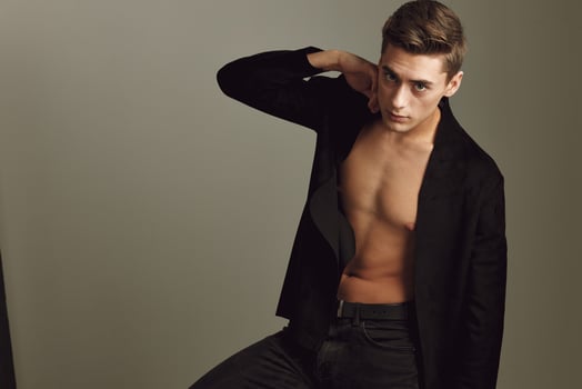 guy with unbuttoned black shirt fashion hairstyle posing studio self-confidence photo