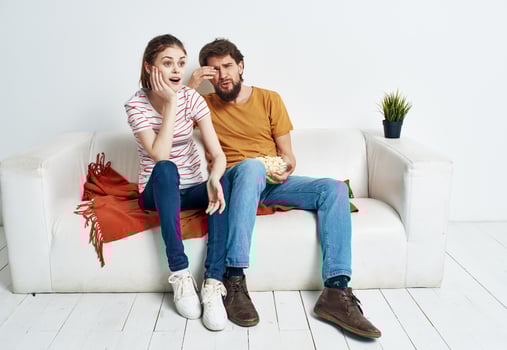 Emotional man and woman on the couch orange plaid flower in a pot chatting friends photo