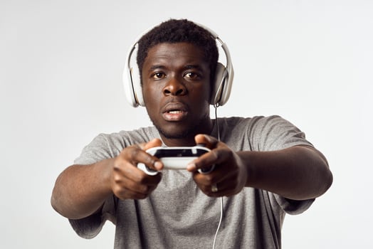 a man of african appearance in headphones with a gamepad in his hands plays video games technology photo