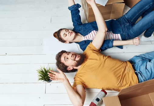 Man and woman with boxes on the floor a flower in a pot moving to repair work photo
