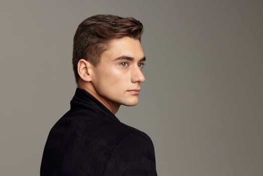 Handsome young guy fashionable hairstyle black jacket attractive look luxury model close-up photo
