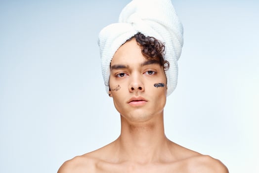 man with bare shoulders towel on head cream clean skin cosmetology photo