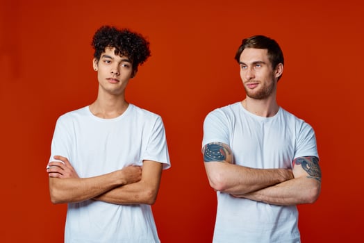 two friends in white t-shirts construction teams he emotions red background photo