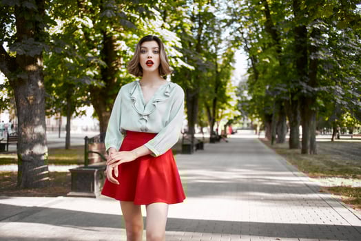 pretty woman walking in the park in red skirt outdoors photo