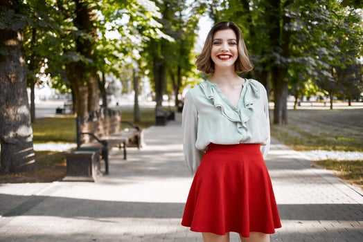 pretty woman walking in the park in red skirt outdoors photo