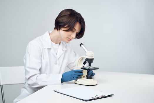 cheerful female laboratory assistant in white coat microscope professional science experiments photo