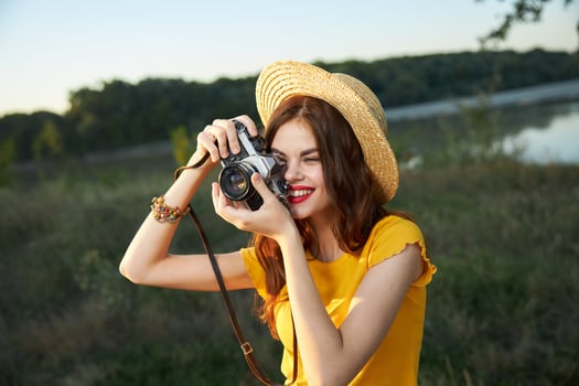 woman photographer in hat looking into the camera lens smile nature hobby photo