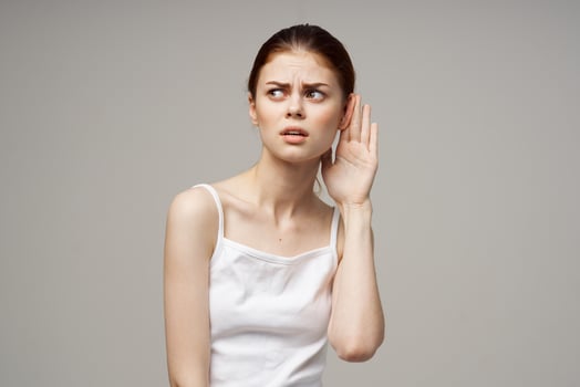 sick woman poor hearing disorders in white t-shirts light background photo
