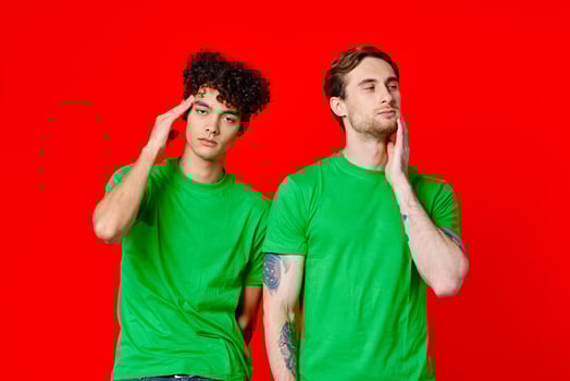 two men in green t-shirts are standing side by side communication emotions friendship photo