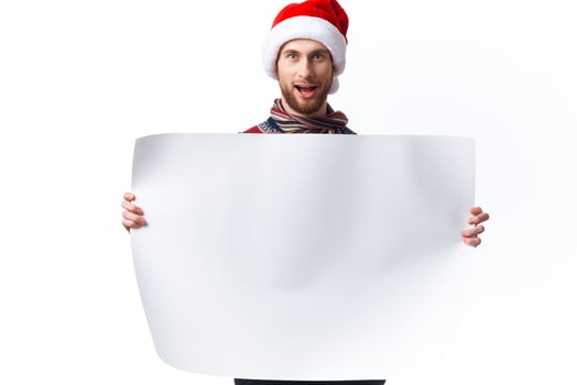 Cheerful man in a christmas hat with white mockup poster christmas copy-space studio photo