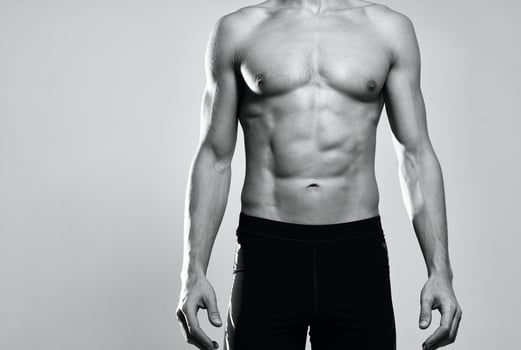 man in black shorts inflated torso black and white photo posing