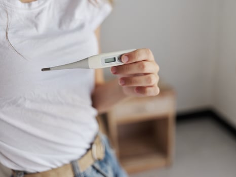 women checking the temperature with a thermometer close-up photo