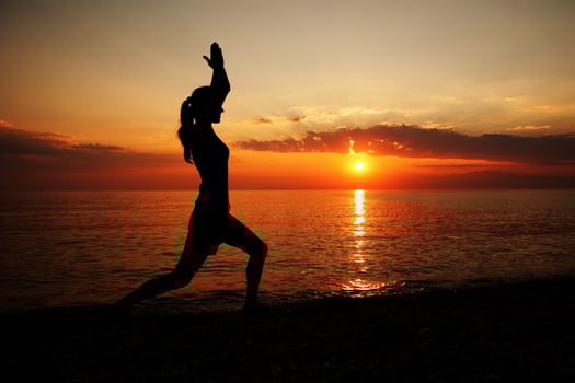 A woman at the beach doing yoga photo