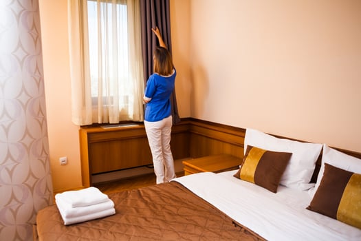 A maid working in a hotel room photo