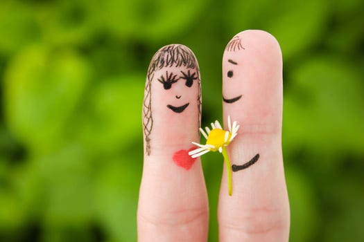 Face painted on fingers. Man is giving flowers to a woman. photo