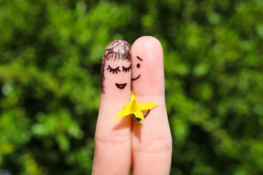 Face painted on fingers. Man is giving flowers to a woman. photo