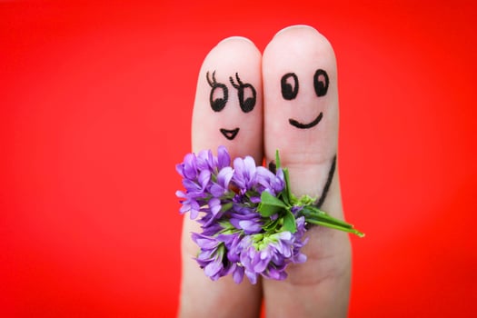 Face painted on fingers. Man is giving flowers to a woman. photo