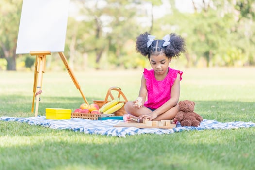 Child girl playing with wooden toy outdoors, Cute little girl play toy in the garden photo