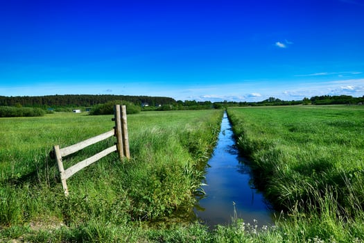 picturesque spring landscape with blue sky and green fields photo