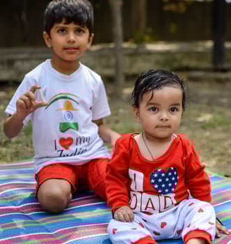 Two happy boys in society park, happy Asian brothers who are smiling happily together. Brothers play outdoors in summer, best friends. Toddler baby boy playing with his happy brother in the garden photo