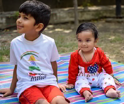 Two happy boys in society park, happy Asian brothers who are smiling happily together. Brothers play outdoors in summer, best friends. Toddler baby boy playing with his happy brother in the garden photo
