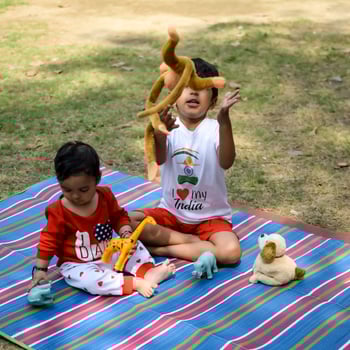 Two happy boys in society park, happy Asian brothers who are smiling happily together. Brothers play outdoors in summer, best friends. Toddler baby boy playing with his happy brother in the garden photo