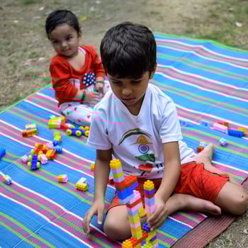 Two happy boys in society park, happy Asian brothers who are smiling happily together. Brothers play outdoors in summer, best friends. Toddler baby boy playing with his happy brother in the garden photo