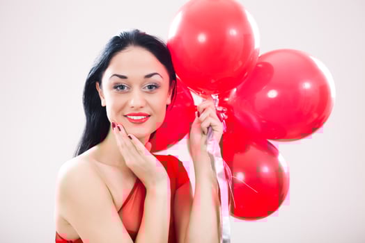 A woman holding red balloons photo