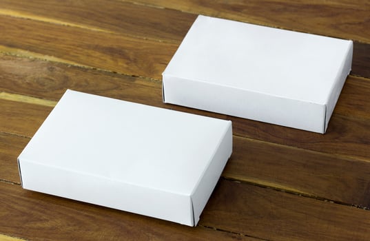 blank white cardboard package box mockup on dark wooden table photo