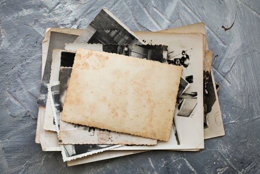Stack old photos  on grey background.  Postcard rumpled and dirty vintage.