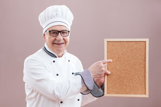 A chef pointing to a display photo