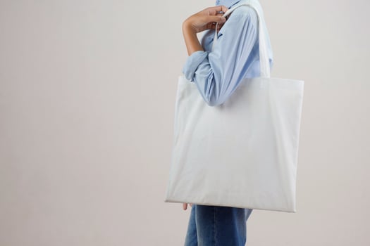 young woman holding eco cotton bag on white background photo