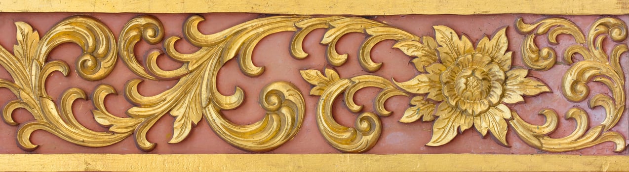 Pattern of gold flower carved on stucco design of native wall, Thai style in temple photo