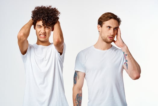 two friends in white t-shirts hold their heads emotions photo