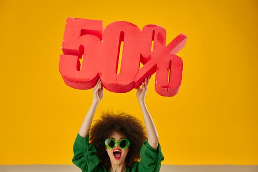 Beautiful fashionable girl green dress afro hairstyle dark glasses fifty percent in hands yellow background unaltered photo