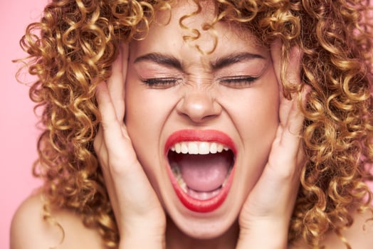woman Shouts and covered her ears with her hands red lips background photo