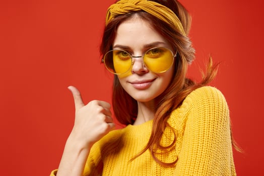 woman in yellow glasses with a bandage on her head yellow sweater Hipster red background photo